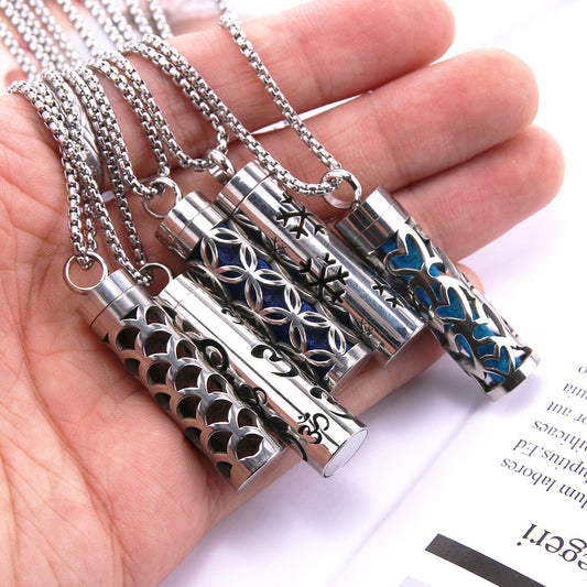 Stainless steel aromatherapy pendant necklaces in hand showing designs for essential oil diffusing