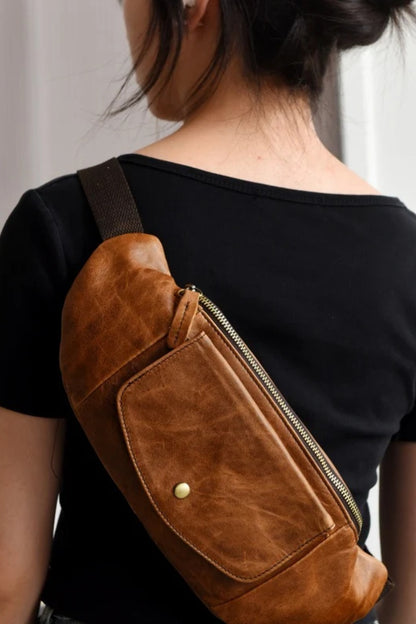 Back view of the tan leather crossbody sling bag worn over the shoulder